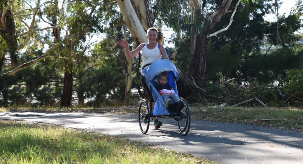 image - running through the park pushing toddler sitting in a stroller is how this mother captures time for herself