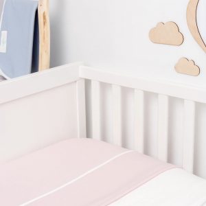product photo of pink merino wool blanket on cot